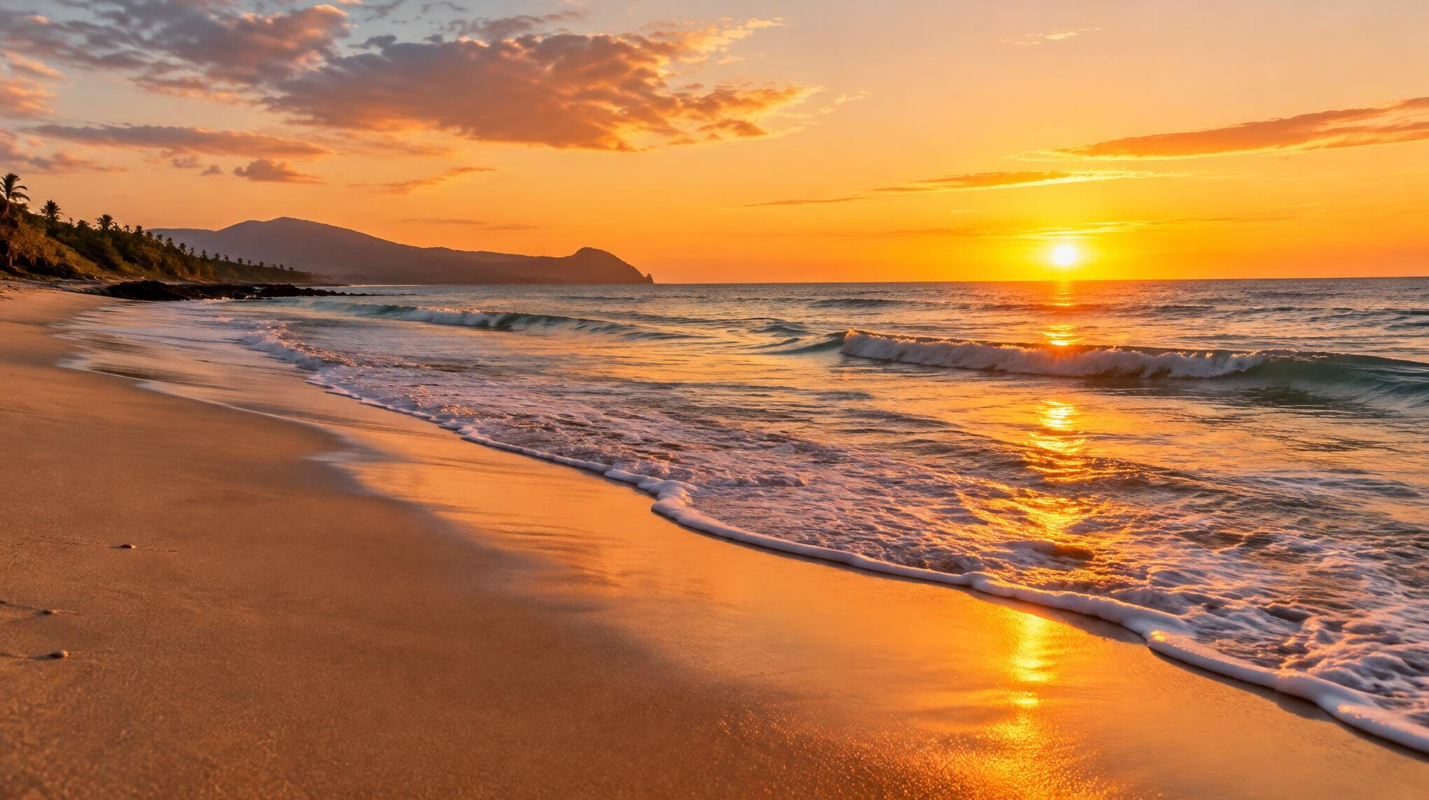 Sandy beach with gentle waves at sunset