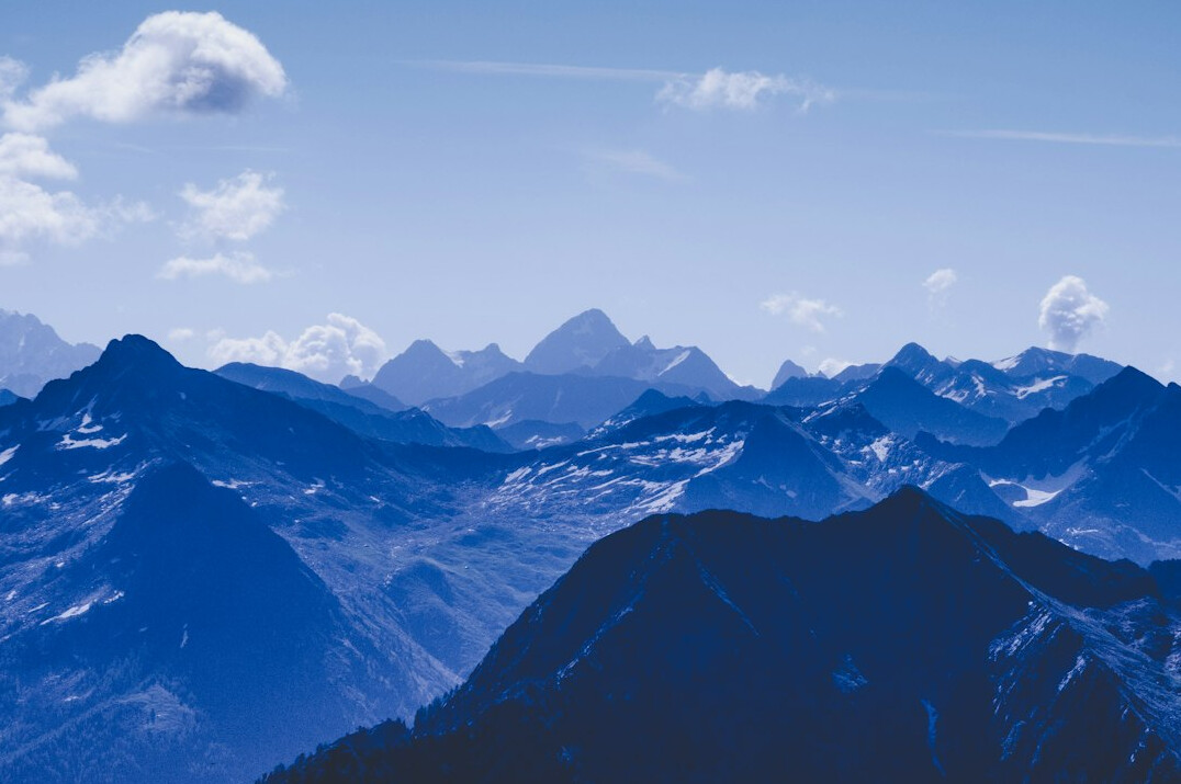 Snow-capped mountain peaks under a blue sky