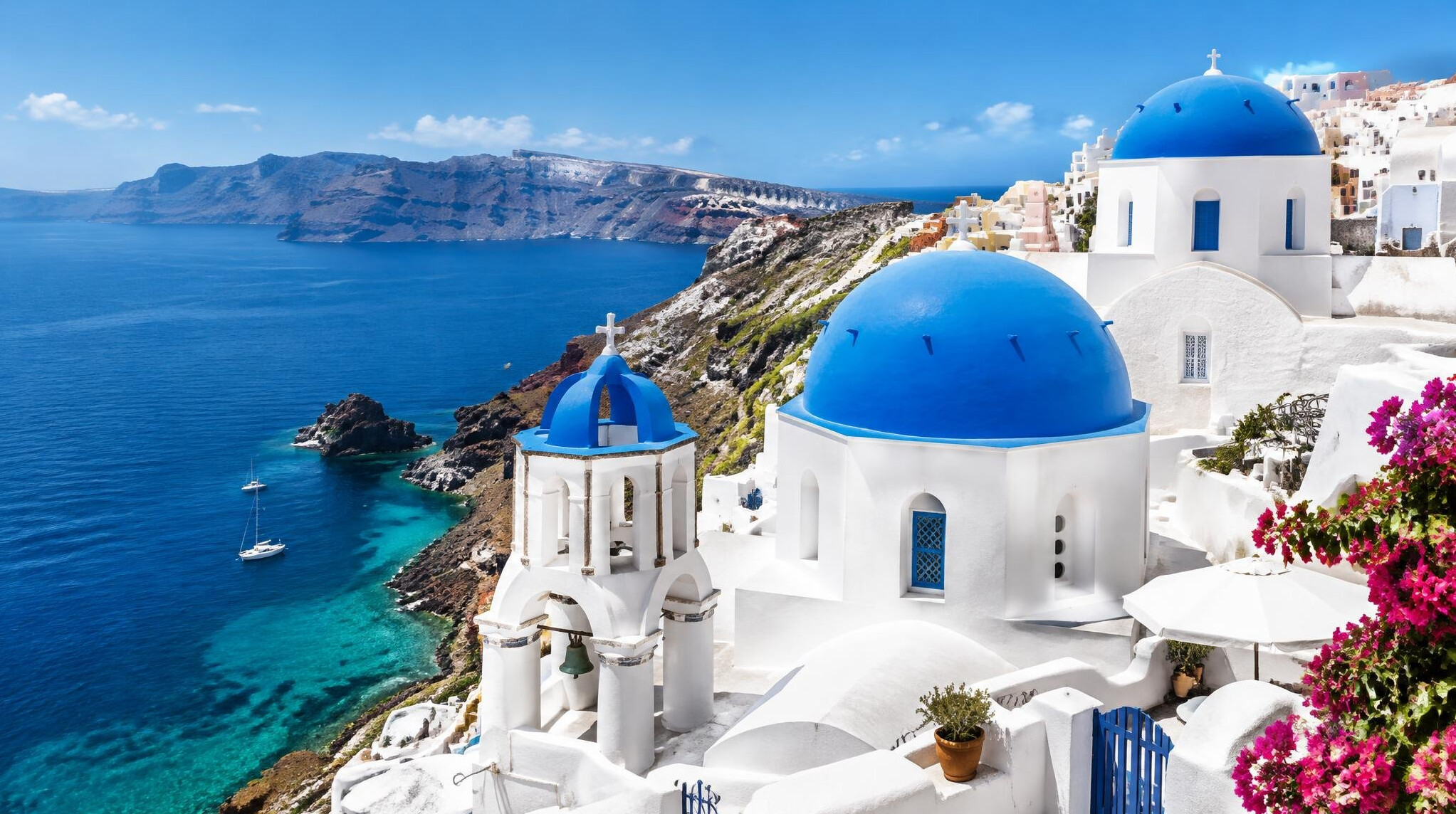 White houses and blue domes on a Greek island above the sea