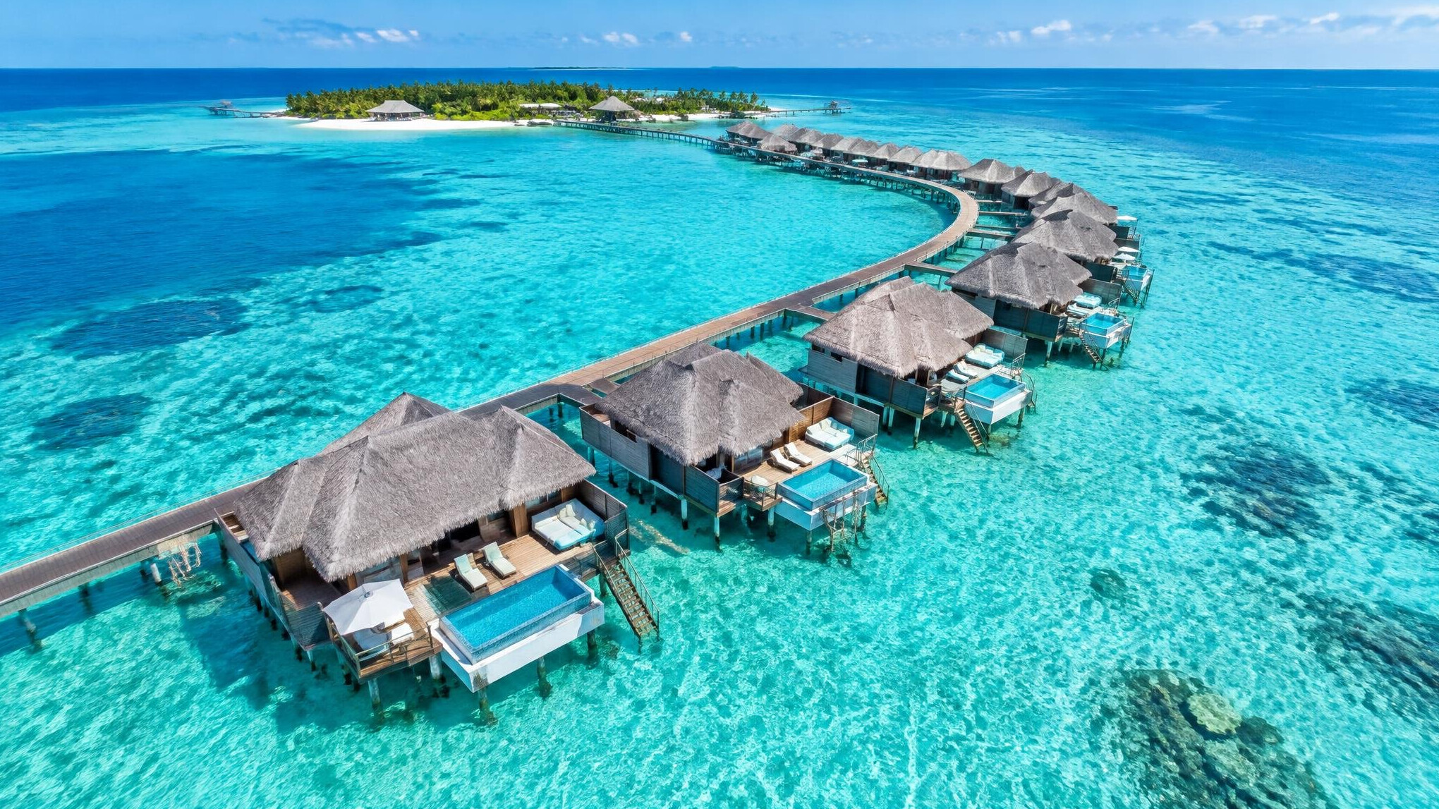 Overwater bungalows above a turquoise lagoon in the Maldives